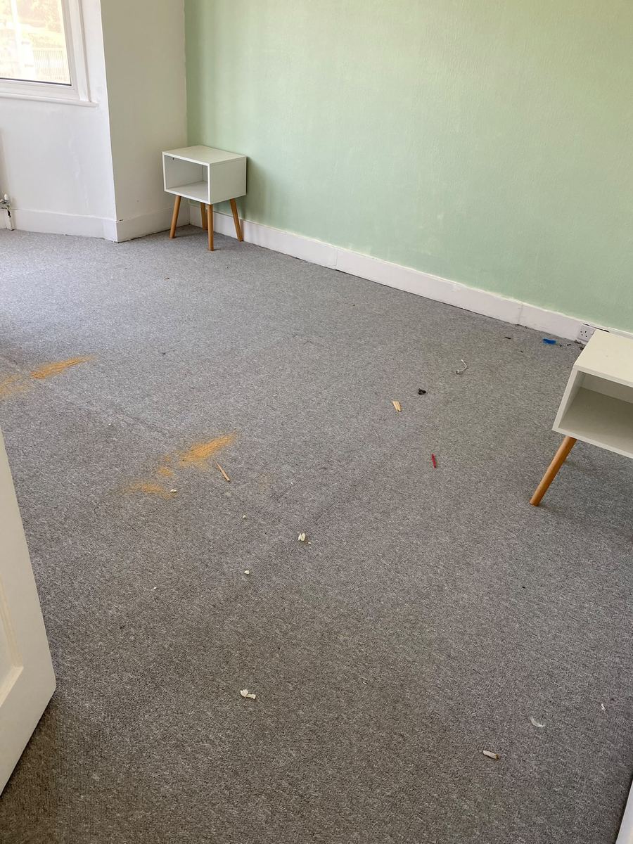 Bedroom carpet before cleaning, with debris and staining