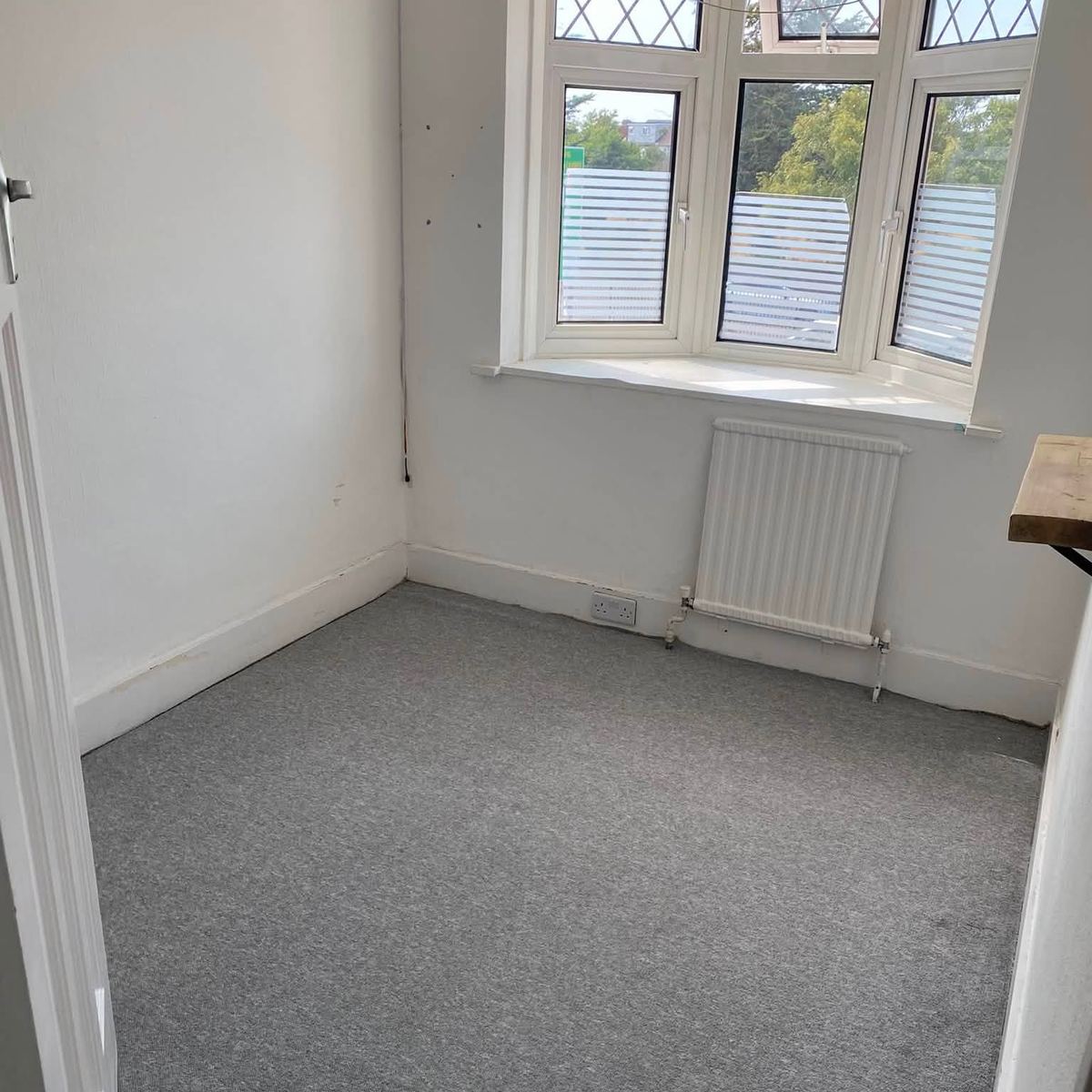 Bedroom with clean windows and a vacuumed carpet
