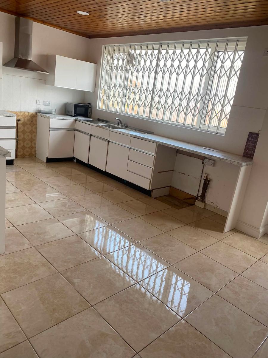 Kitchen with a polished tiled floor reflecting the window